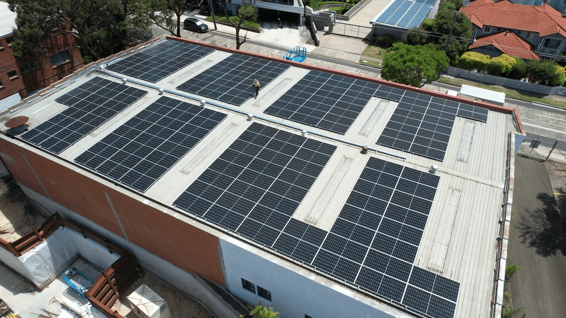 A commercial rooftop array running to the edge of a large flat roof.
